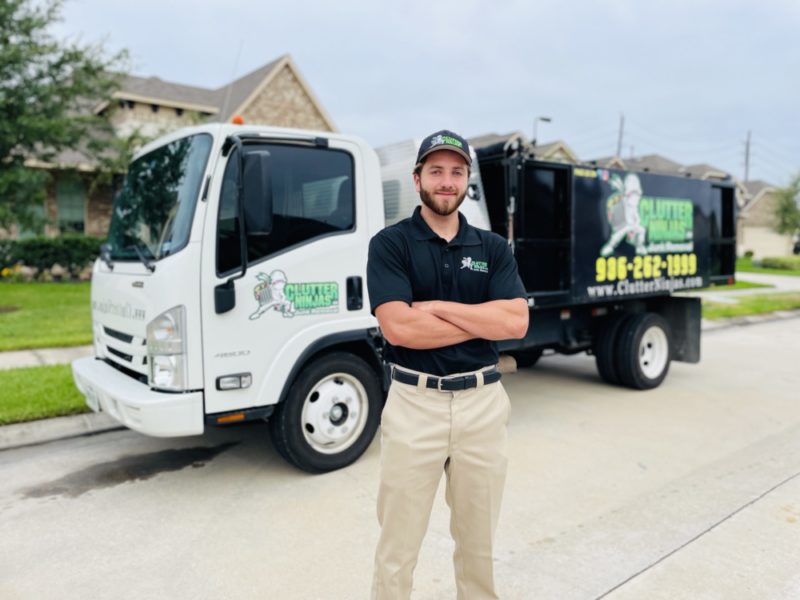 A Clutter Ninjas junk removal expert posing with a junk truck